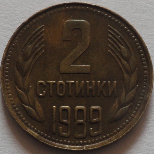 Монета от 2 стотинки, 1989 г., с номинал в центъра и житни класове от двете страни, символизиращи плодородие и селско стопанство.