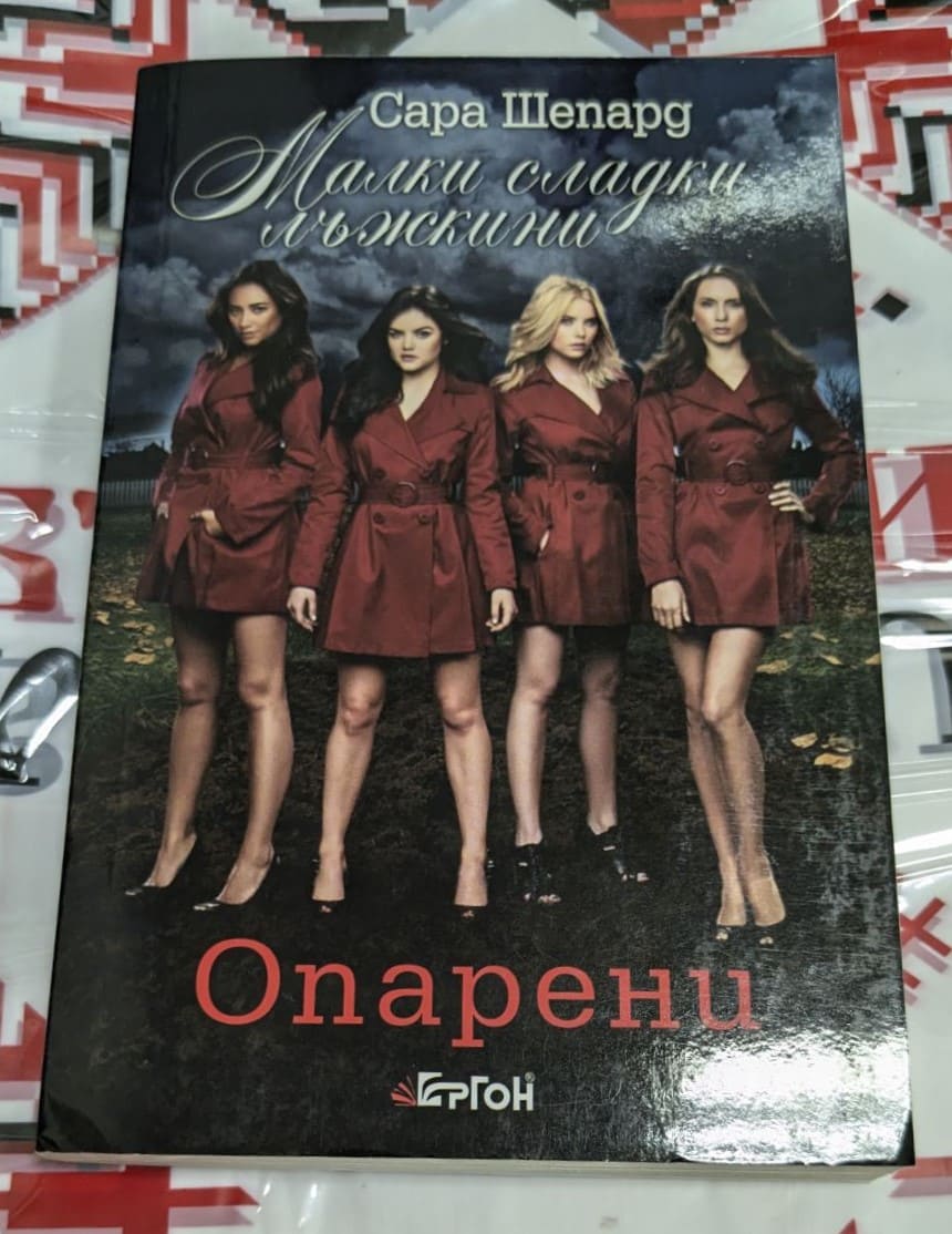 Корицата на дванадесетата книга от поредицата "Малки сладки лъжкини" на Сара Шепард, "Опарени", публикувана през 2013 година, с меки корици.