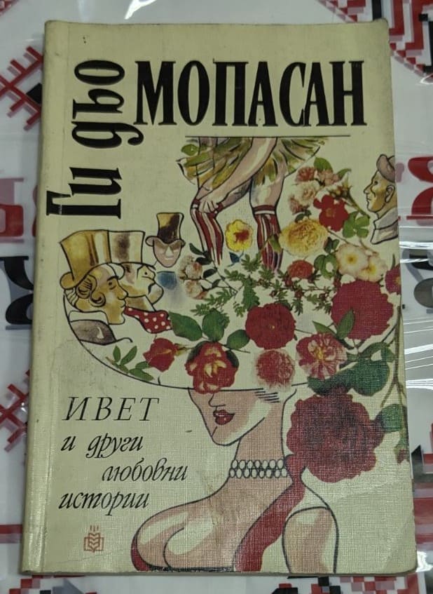 Корица на книгата „Ивет и други любовни истории“ от Ги дьо Мопасан (1992), изобразяваща жена с голяма шапка, украсена с цветя и лица на персонажи.