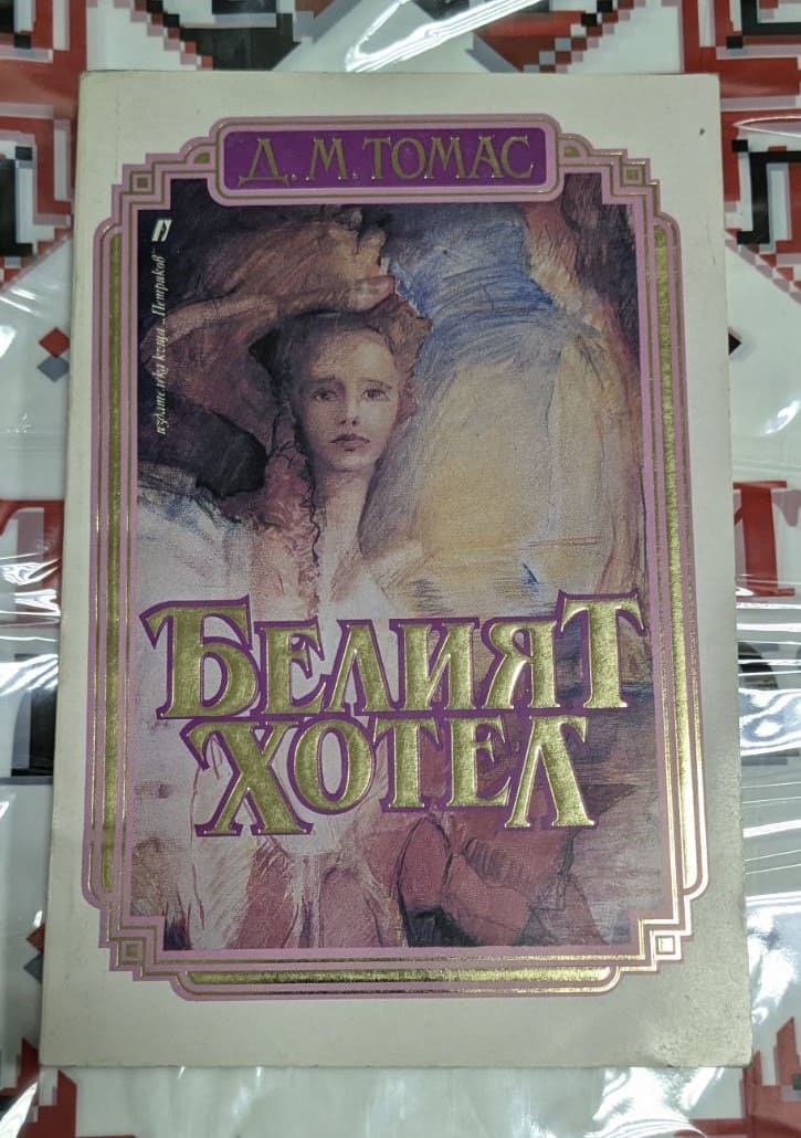 Корица на книгата „Белият хотел“ от Д. М. Томас (1991) с илюстрация на жена и златисто заглавие на бял фон.