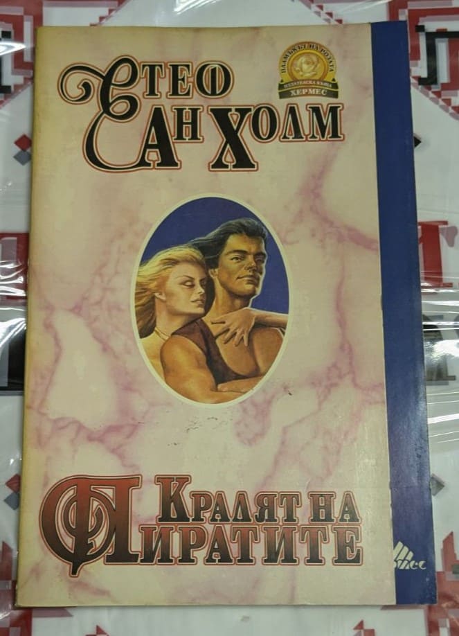 Корицата на роман „Кралят на пиратите“ от Стеф Ан Хоам, показваща пиратски кораб в бурно море с фигурата на капитан на преден план.