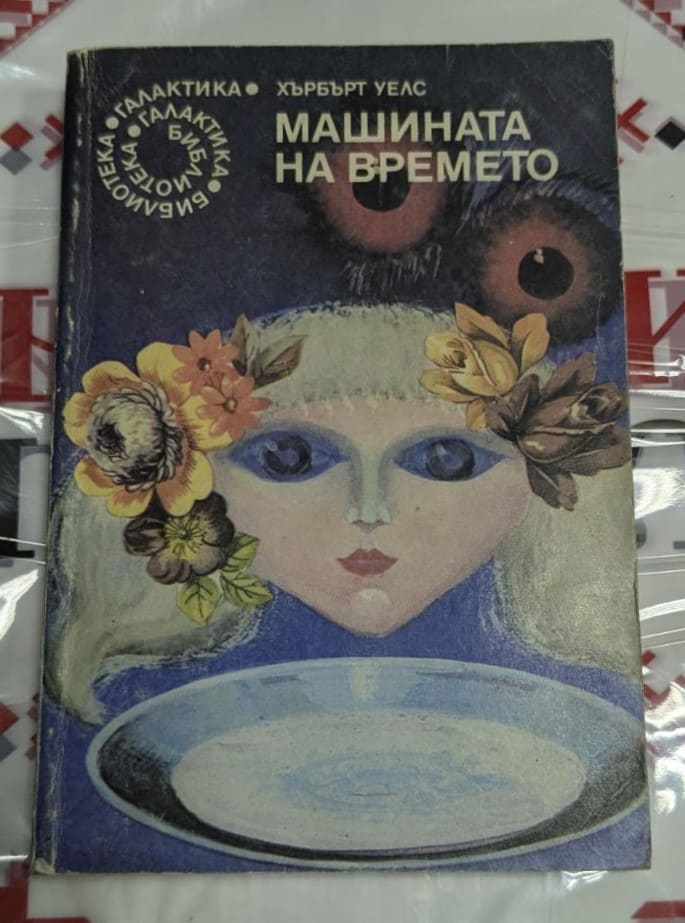 Първо издание на "Машината на времето" от Хърбърт Уелс, 1984 г., корица с лице на жена, цветя и чиния, част от "Библиотека Галактика".