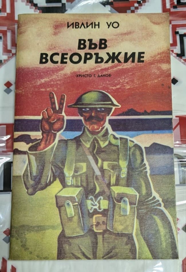 Корица на романа „Във всеоръжие“ от Ивлин Уо, част от трилогията, първо издание, с фокус върху военни конфликти и сатиричен поглед към обществото.