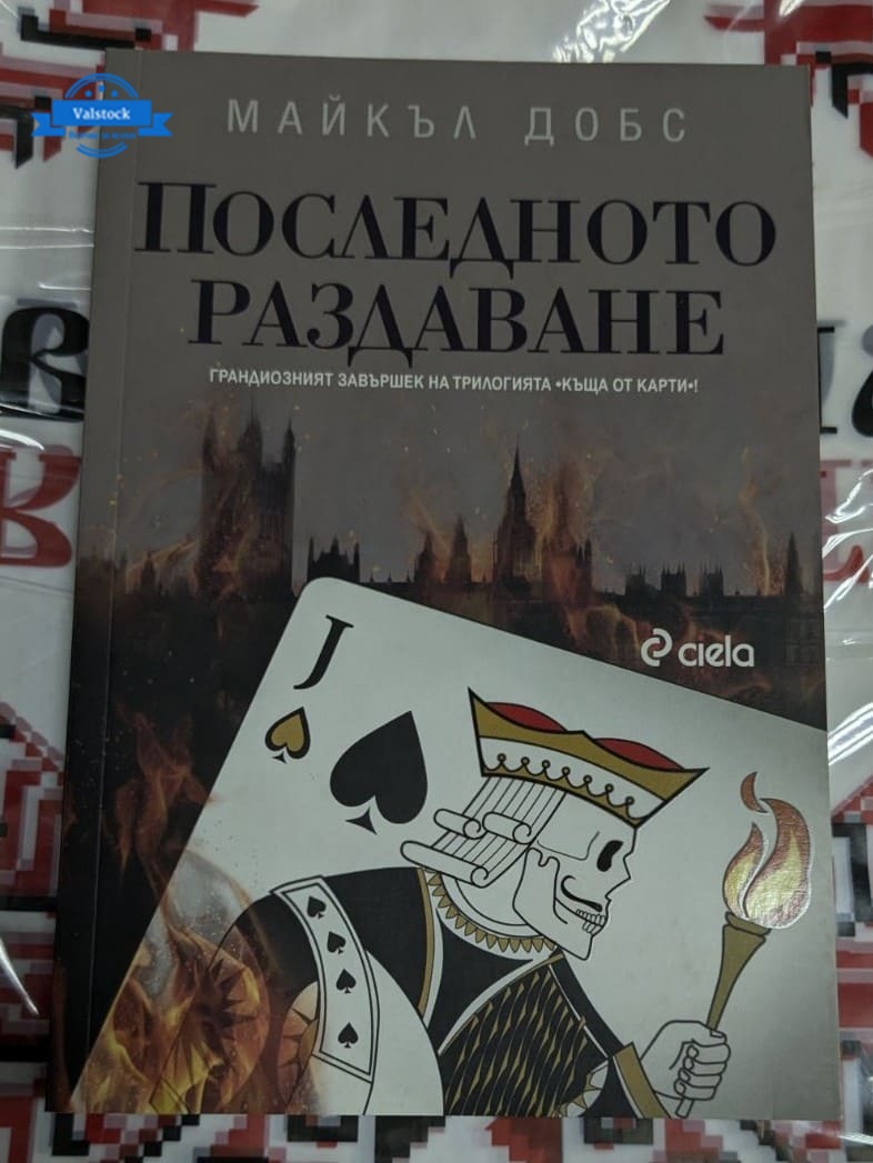 Книга „Последното раздаване“ от Майкъл Добс, първо издание, 2017 г. – корица, символизираща политическа интрига и напрежение.