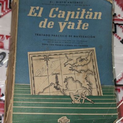 Стара книга със синьо-зелена корица, озаглавена „El Capitán de Yate“, с илюстрация на морска карта, компас и секстант.