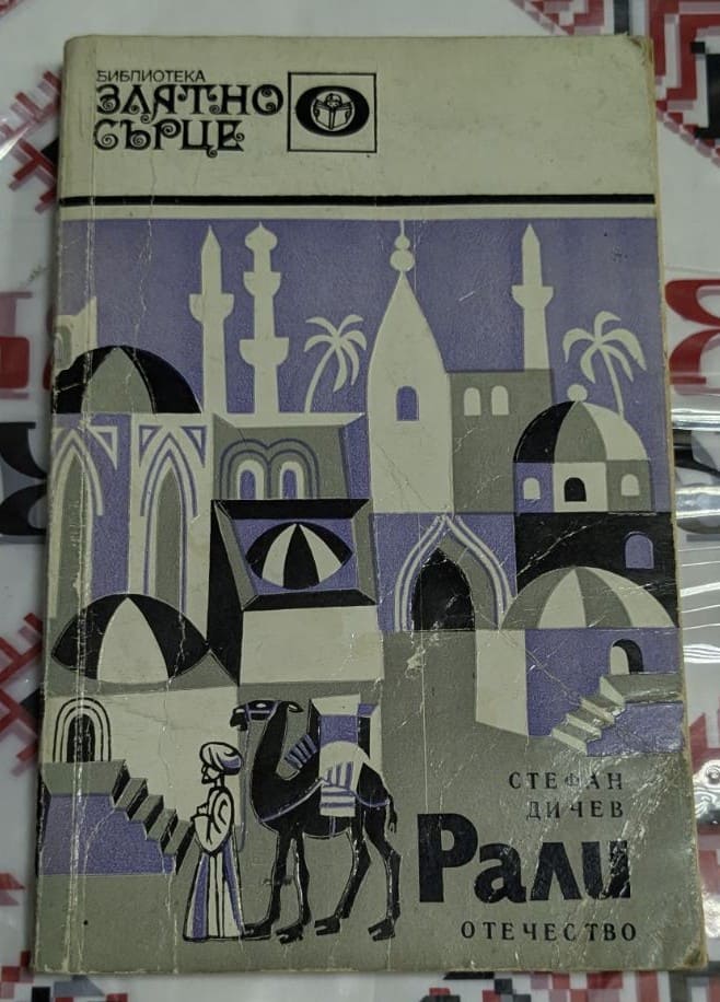 Книга „Рали“ от Стефан Дичев, издание от библиотека „Златно сърце“, с корица, изобразяваща ориенталски град и керванджия с камила.