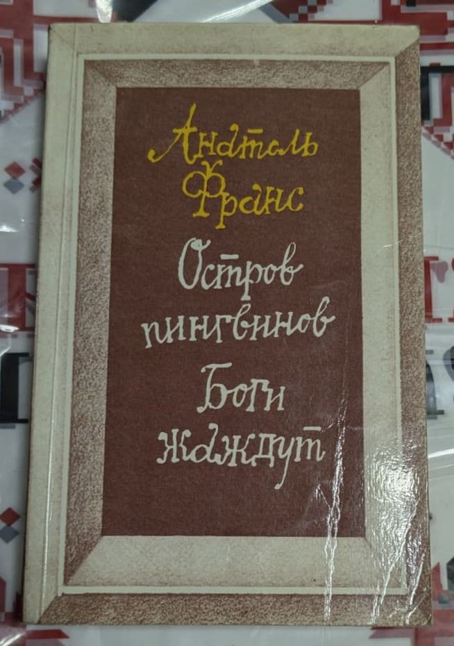 Разтворена книга с руския превод на „Островът на пингвините“ от Анатол Франс, издание на „Правда“ от 1984 г., с илюстрация на автора.