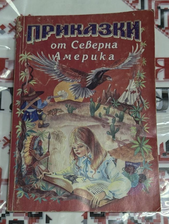 Корица на книгата „Приказки от Северна Америка“ с илюстрации на момиче с отворена книга, орел в полет, индианец, ковбой и пустиня с кактуси.