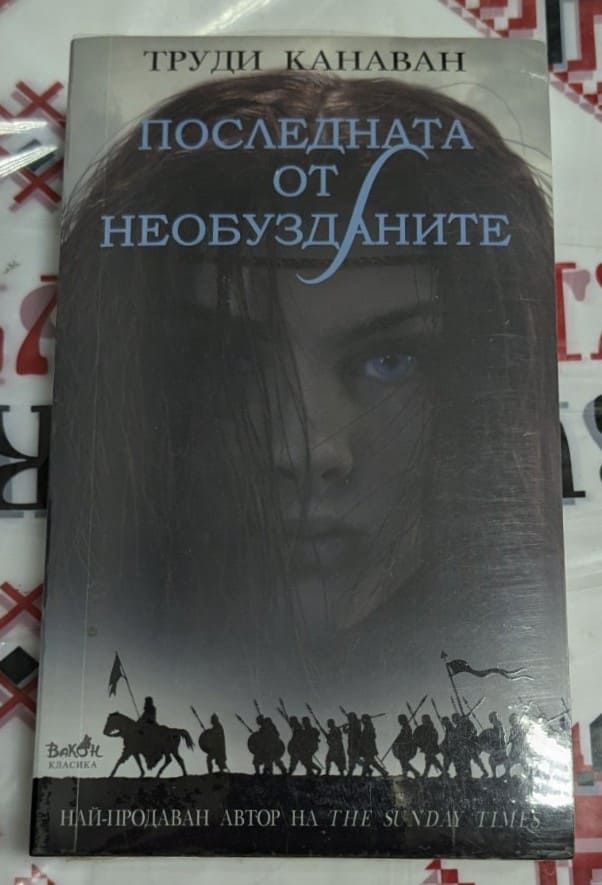 Корица на книгата 'Последна от необузданите' от Труди Канаван с мистичен пейзаж и герои. Лого на VAKXIS CLASSIC.