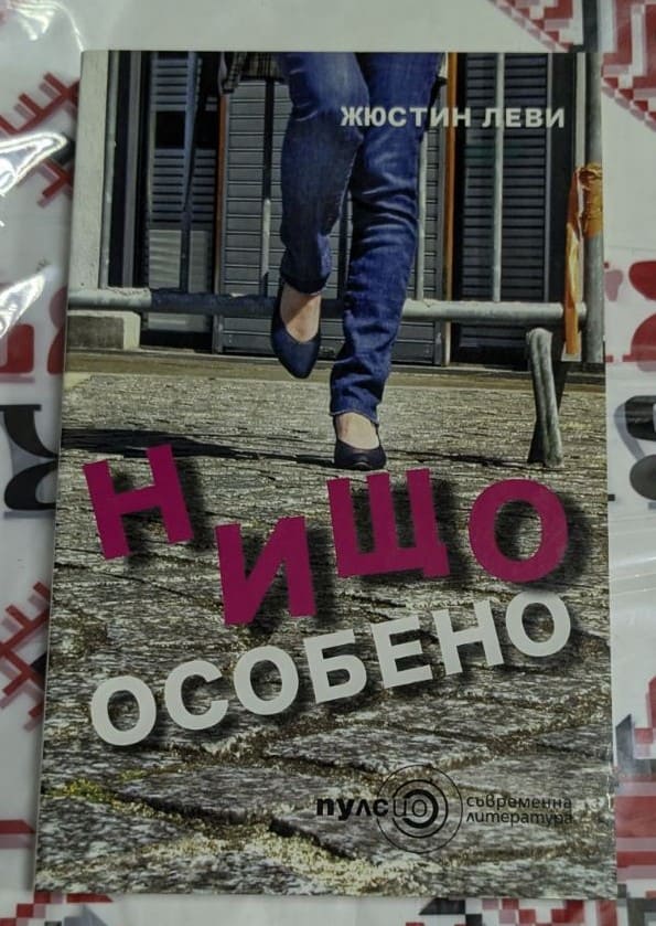 Корицата на книгата „Нищо особено“ от Жюстин Леви, с изображение на жена, преминаваща улица – символ на преход и лична борба.