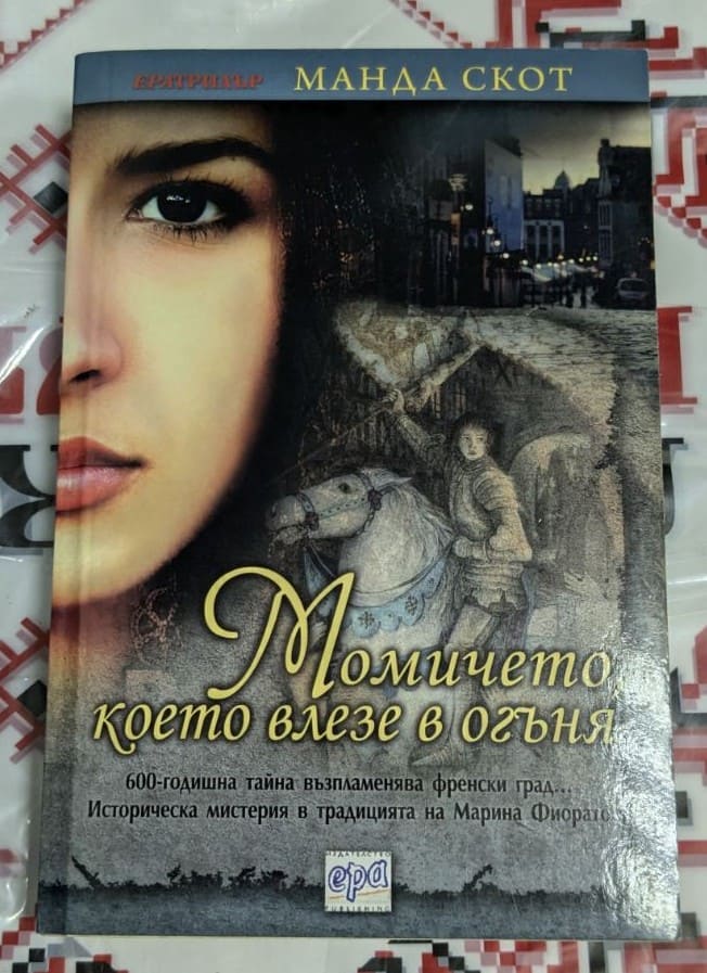 Корица на книгата 'Момичето, което влезе в огъня' с драматичен дизайн, вдъхновен от Средновековна Франция. Издателство EPA