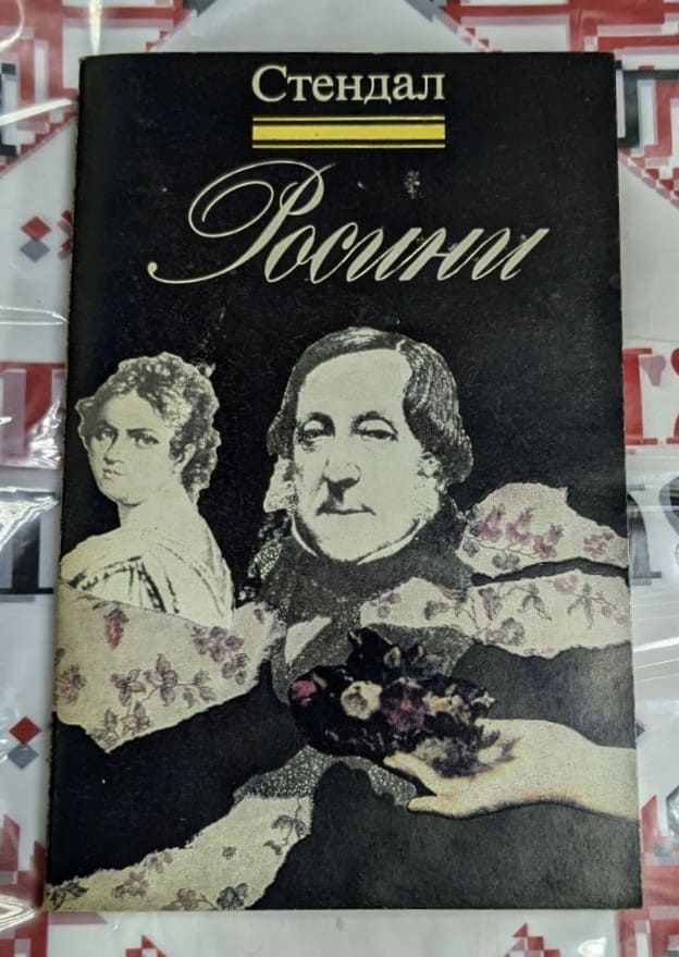 Корица на книгата „Росини“ от Стендал, с черен фон и стилизирани портрети на композитора и жена, обгърнати от цветни декоративни елементи.