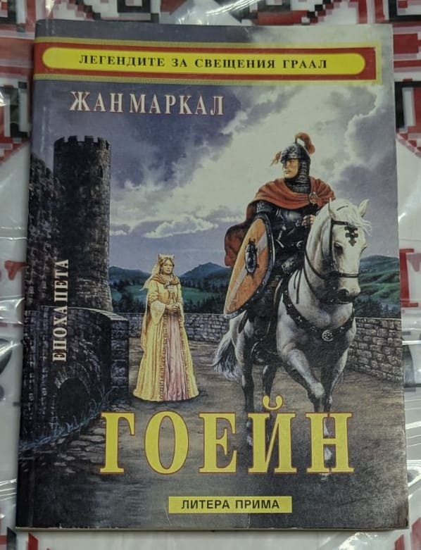 Корица на книгата „Гоейн“ от Жан Маркал – рицар на бял кон пред средновековен замък, част от поредицата „Легендите за Свещения Граал“