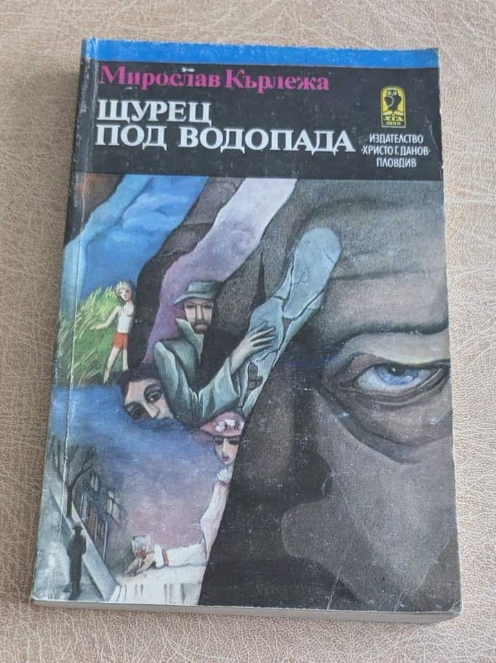 Стара книга „Щурец под водопада“ от Мирослав Кърлежа, художествена литература с меки корици и илюстрована корица.